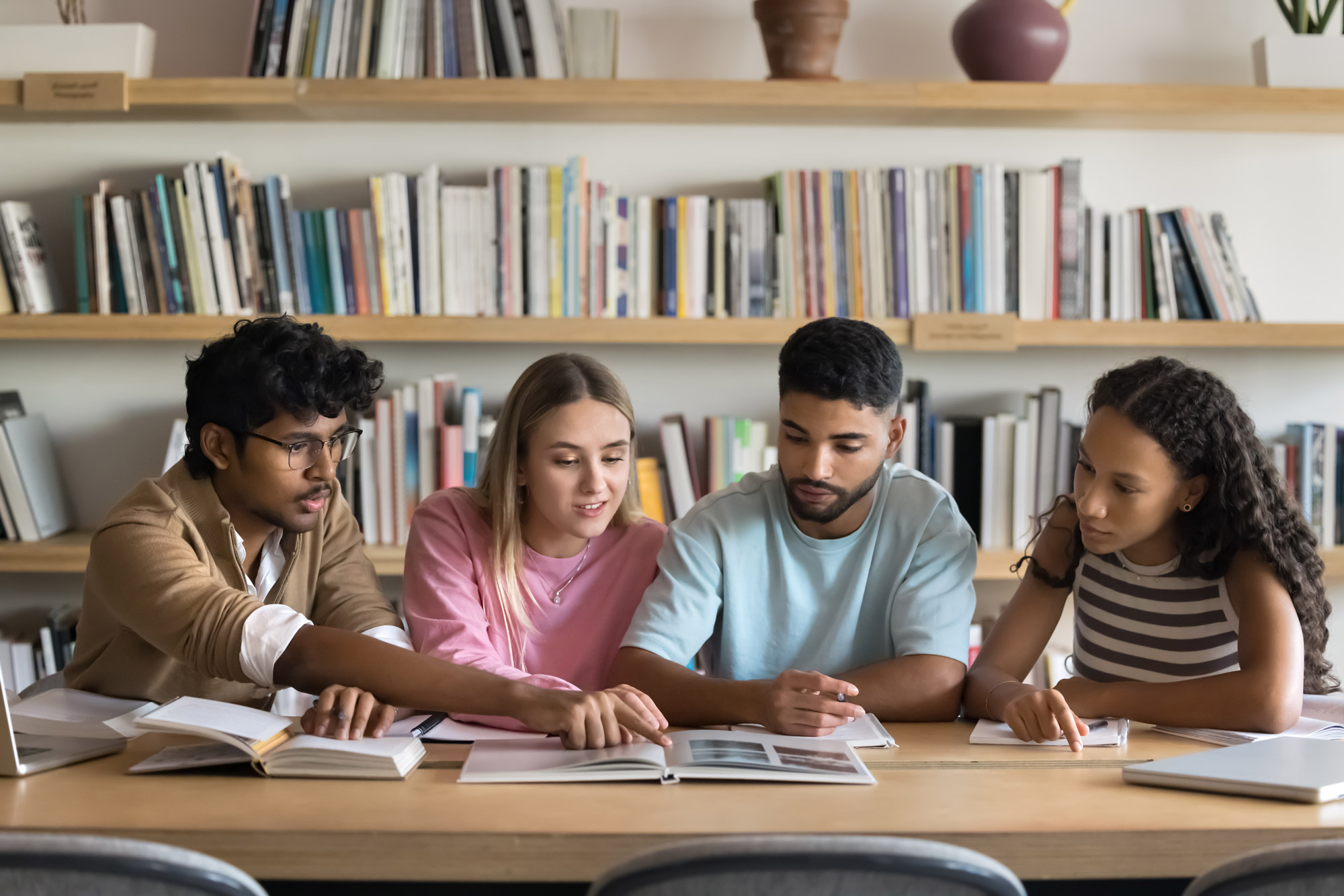 Gruppe von vier Studenten die sich helfen